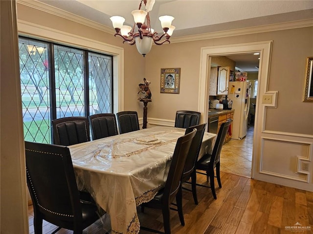 dining area featuring a chandelier, ornamental molding, and wood finished floors
