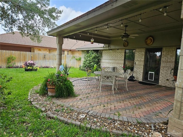 view of patio featuring outdoor dining area, ceiling fan, and fence