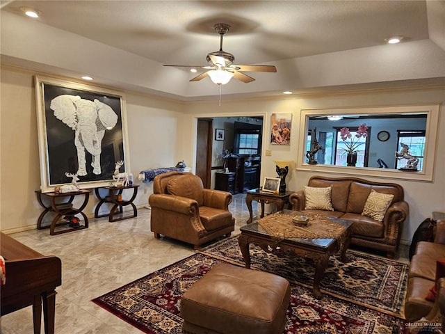 living room featuring a raised ceiling, baseboards, a ceiling fan, and recessed lighting