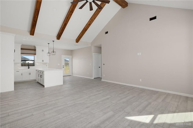 unfurnished living room featuring ceiling fan, light hardwood / wood-style floors, beam ceiling, and high vaulted ceiling