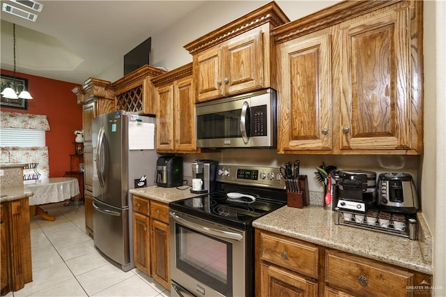 kitchen with light stone countertops, an inviting chandelier, light tile patterned floors, and appliances with stainless steel finishes