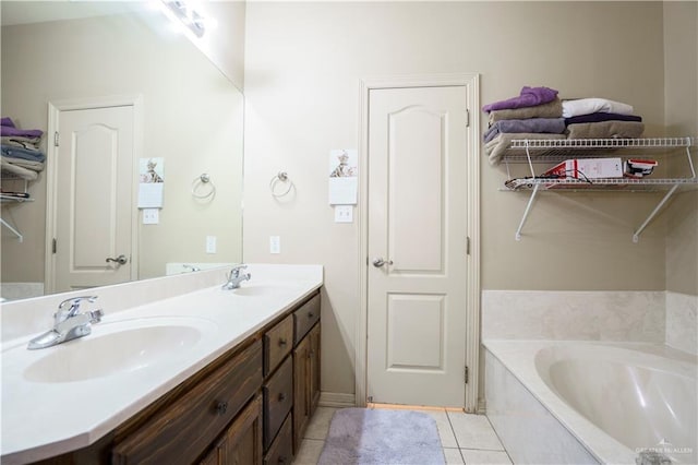 bathroom featuring tile patterned floors, vanity, and tiled tub