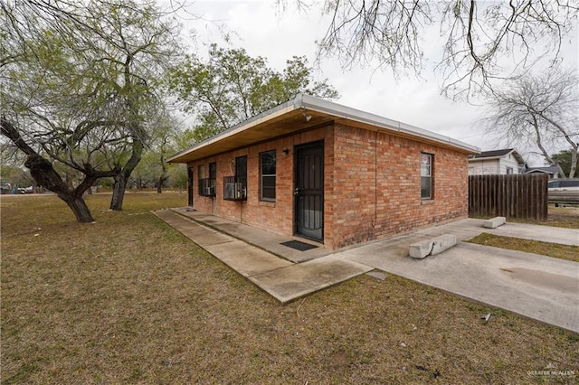 view of side of home with a lawn and a patio area