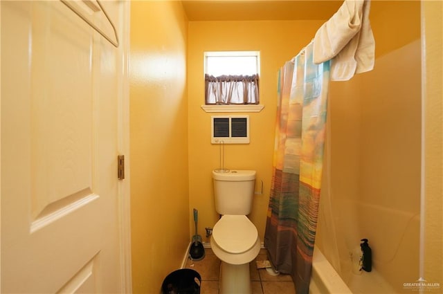 bathroom featuring tile patterned flooring, shower / tub combo, and toilet