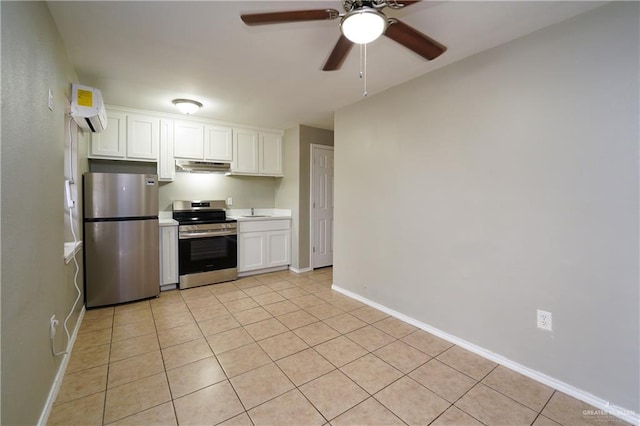 kitchen with light tile patterned flooring, appliances with stainless steel finishes, a wall unit AC, ceiling fan, and white cabinets