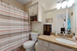 2105 Treasure Oaks Dr, Harlingen, TX 78550 - bathroom featuring toilet, vanity, and a shower with curtain