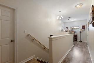 2105 Treasure Oaks Dr, Harlingen, TX 78550 - hallway featuring an upstairs landing, wood finished floors, baseboards, and a chandelier