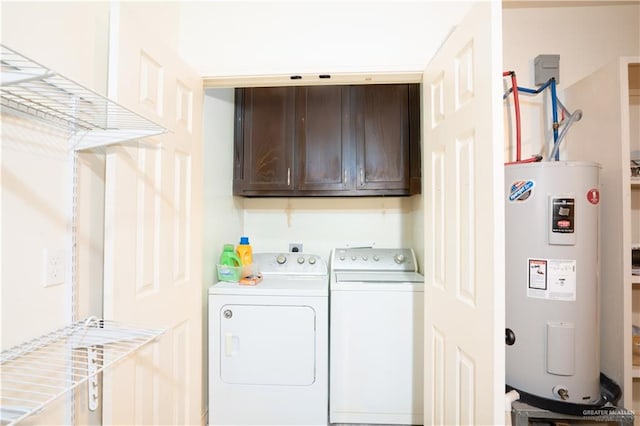 washroom featuring cabinets, electric water heater, and washing machine and clothes dryer