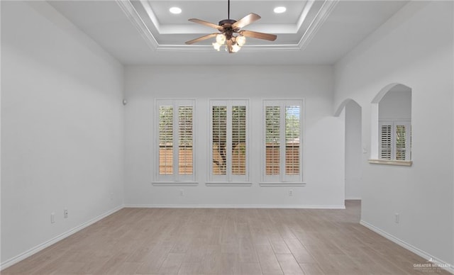 2605 Jeff St, Harlingen, TX 78550 - spare room featuring a ceiling fan, light wood-style floors, a tray ceiling, arched walkways, and ornamental molding