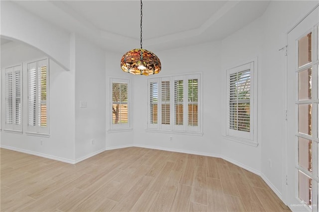 2605 Jeff St, Harlingen, TX 78550 - spare room with light wood finished floors, arched walkways, baseboards, and a raised ceiling