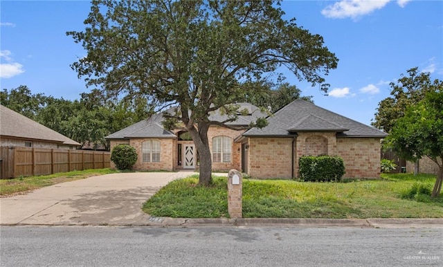 2605 Jeff St, Harlingen, TX 78550 - view of front facade featuring concrete driveway, brick siding, and a shingled roof