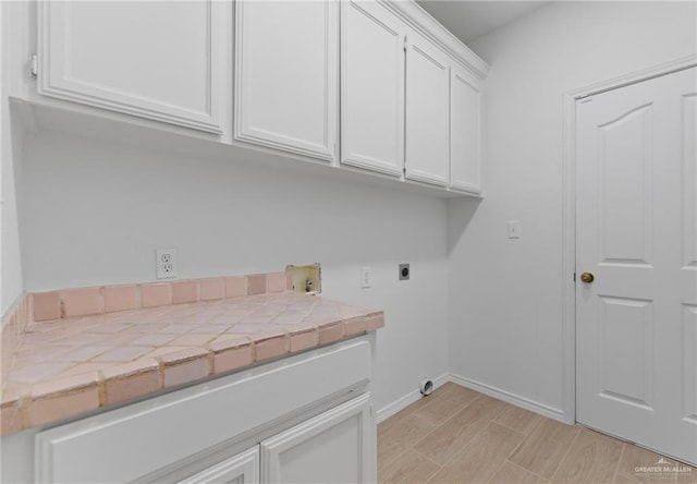 2605 Jeff St, Harlingen, TX 78550 - laundry area with hookup for an electric dryer, cabinet space, baseboards, light wood-style flooring, and hookup for a washing machine