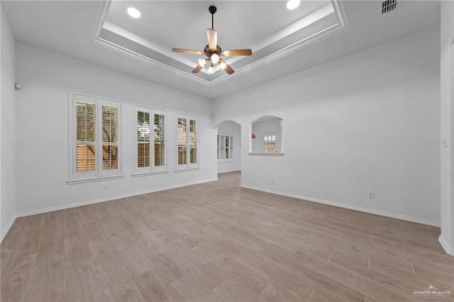 2605 Jeff St, Harlingen, TX 78550 - empty room featuring a raised ceiling, a ceiling fan, light wood finished floors, arched walkways, and recessed lighting
