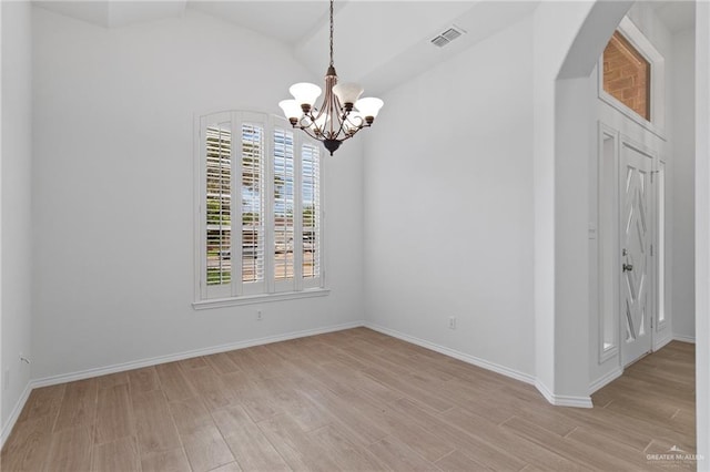 2605 Jeff St, Harlingen, TX 78550 - spare room featuring light wood-type flooring, a chandelier, arched walkways, vaulted ceiling, and baseboards