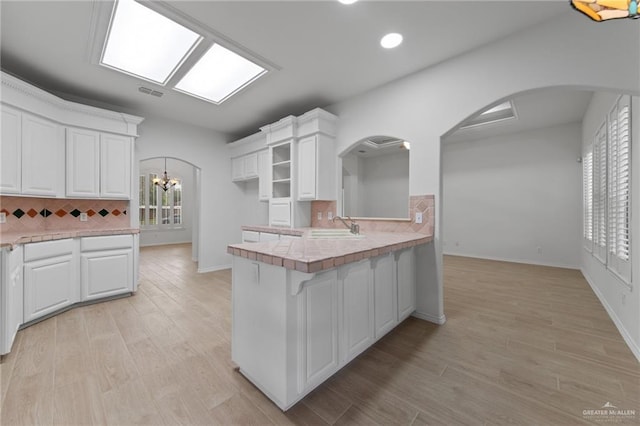 2605 Jeff St, Harlingen, TX 78550 - kitchen with plenty of natural light, decorative backsplash, recessed lighting, arched walkways, and white cabinets