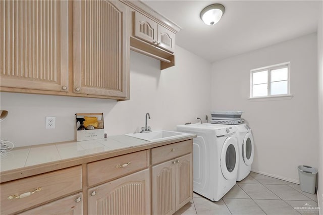 washroom featuring cabinet space, washing machine and dryer, and light tile patterned flooring