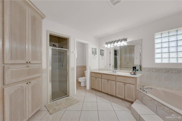 full bath with a shower stall, tile patterned flooring, a bath, toilet, and vanity