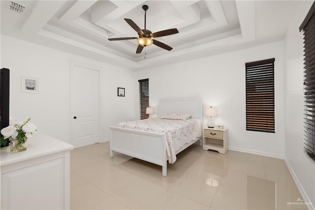 tiled bedroom with a raised ceiling and ceiling fan