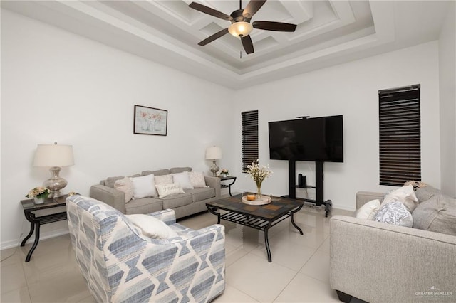 tiled living room featuring a raised ceiling and ceiling fan