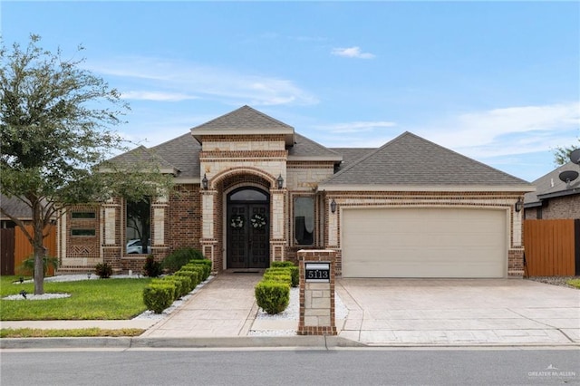 view of front of home with a front yard, french doors, and a garage