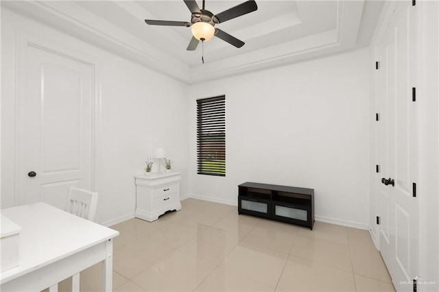 tiled bedroom featuring a raised ceiling and ceiling fan