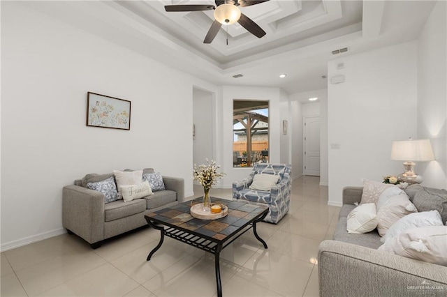 living room featuring light tile patterned floors, a raised ceiling, and ceiling fan