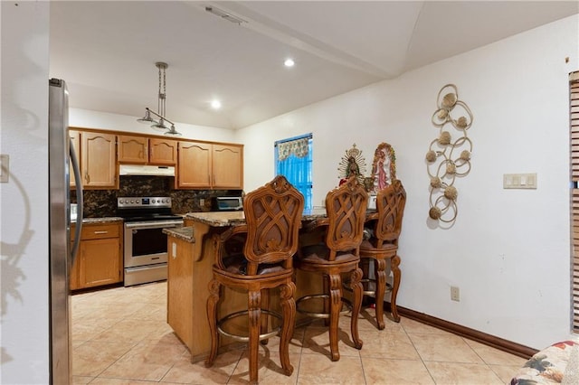 kitchen with stone countertops, a breakfast bar, a peninsula, stainless steel appliances, and under cabinet range hood