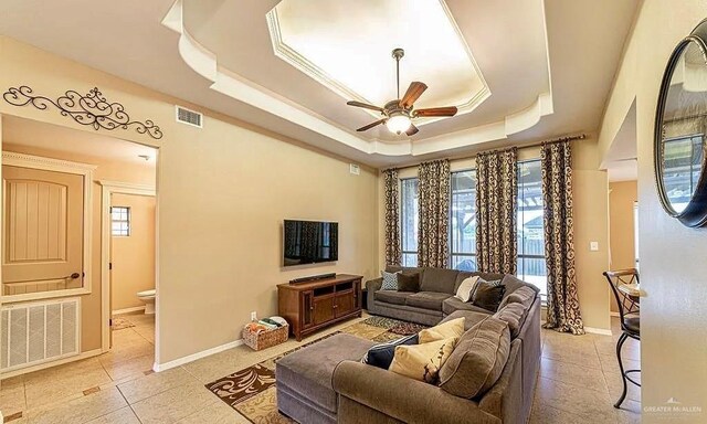 3104 Cactus Dr, Weslaco, TX 78599 - living room with a ceiling fan, light tile patterned flooring, a tray ceiling, and baseboards
