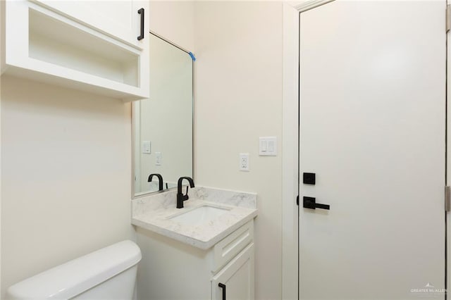 bathroom featuring toilet and vanity