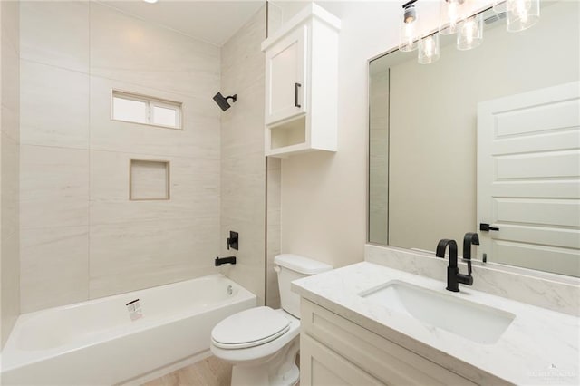 full bathroom featuring toilet, tiled shower / bath combo, and vanity