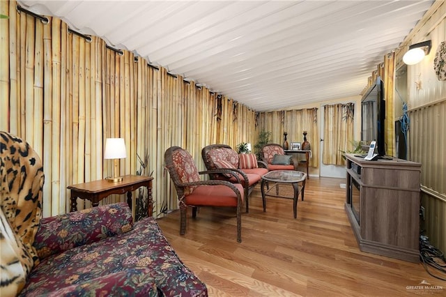 sitting room featuring light wood-type flooring and wood walls