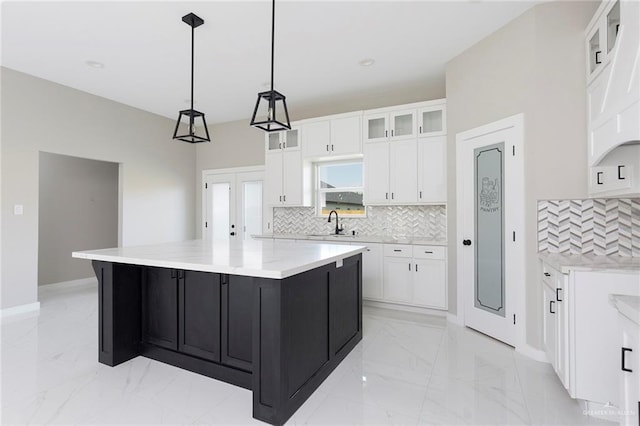 9206 N 25th Ln, Mcallen, TX 78504 - kitchen with backsplash, glass insert cabinets, white cabinets, and a spacious island