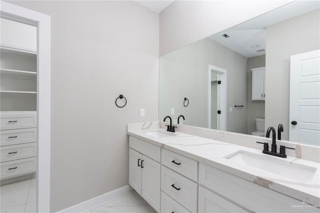 9206 N 25th Ln, Mcallen, TX 78504 - full bath with marble look tile flooring, double vanity, toilet, and baseboards