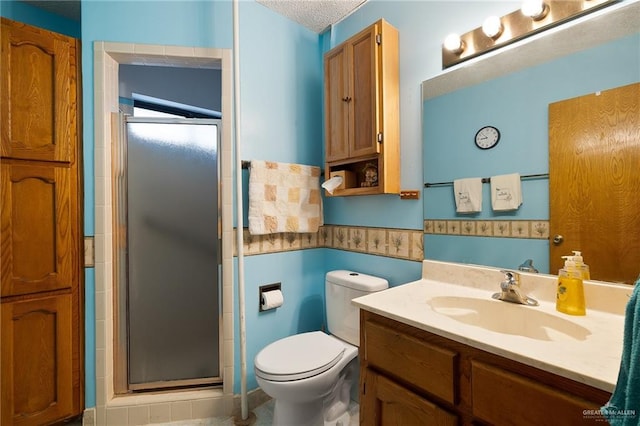 bathroom featuring vanity, a textured ceiling, toilet, and a shower with door