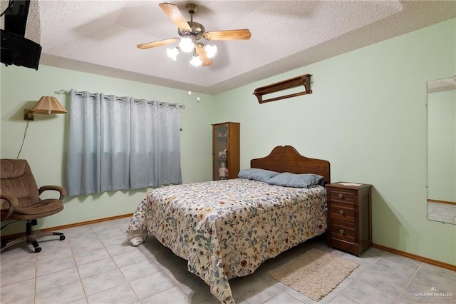 bedroom featuring ceiling fan, light tile patterned floors, and a textured ceiling