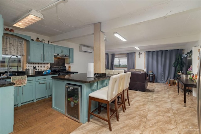 kitchen with a breakfast bar, black stove, tasteful backsplash, a wall mounted AC, and beverage cooler