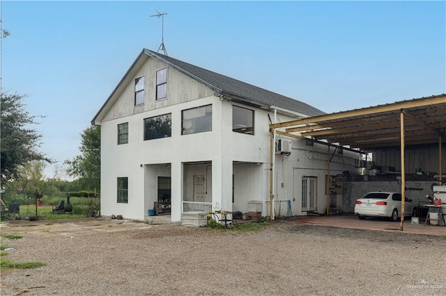 view of front of property featuring a carport and a wall mounted AC