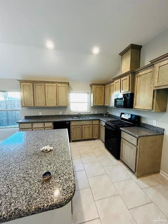 kitchen with black appliances, dark stone countertops, and sink