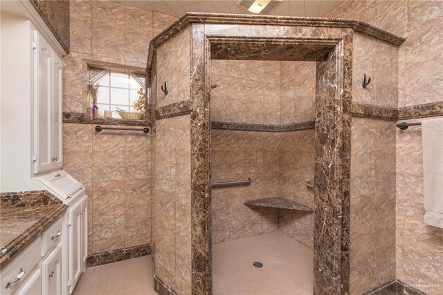 bathroom featuring tiled shower and vanity