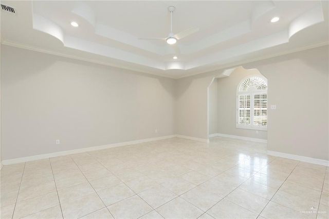 unfurnished room with a raised ceiling, light tile patterned floors, ceiling fan, recessed lighting, and ornamental molding