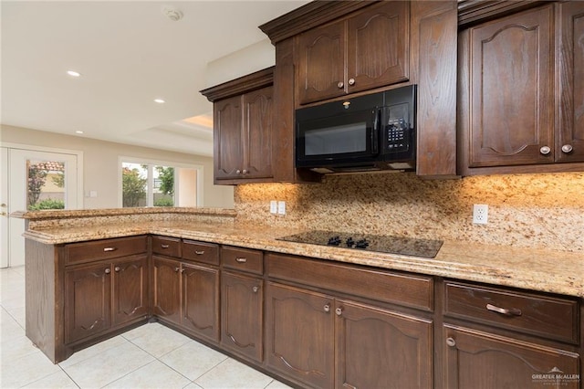 kitchen with black appliances, light tile patterned floors, tasteful backsplash, a peninsula, and dark brown cabinetry
