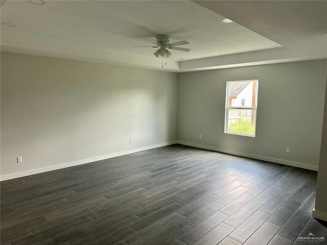 spare room featuring a tray ceiling and ceiling fan