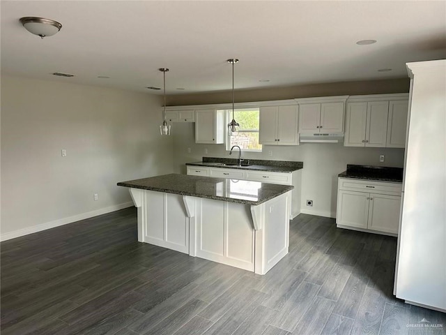 kitchen featuring pendant lighting, a center island, and white cabinetry