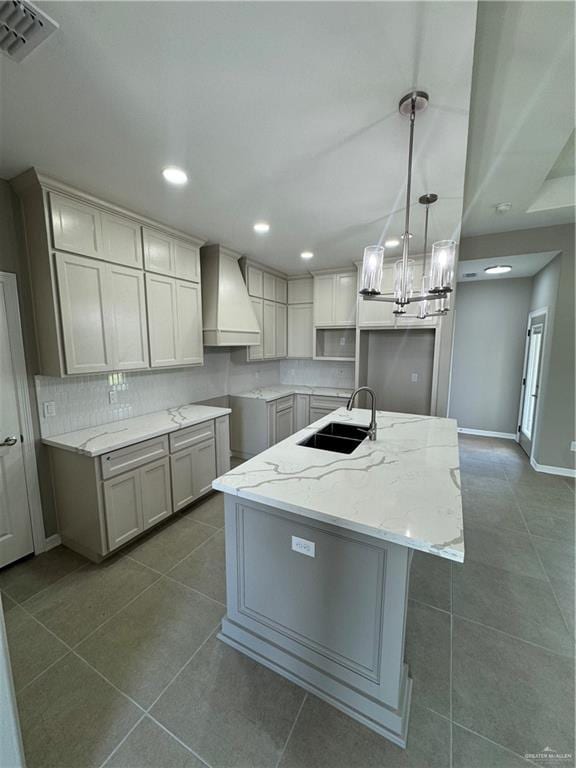 12711 N 37th Ln, Mcallen, TX 78504 - kitchen featuring custom exhaust hood, light stone countertops, a kitchen island with sink, a chandelier, and recessed lighting