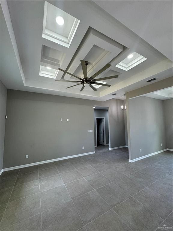 12711 N 37th Ln, Mcallen, TX 78504 - spare room featuring a ceiling fan, a tray ceiling, dark tile patterned flooring, and coffered ceiling