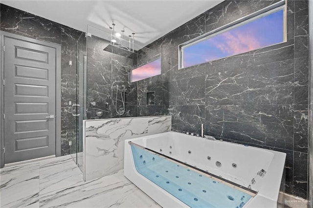 bathroom featuring shower with separate bathtub and tile walls