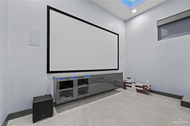 tiled home theater room featuring a skylight