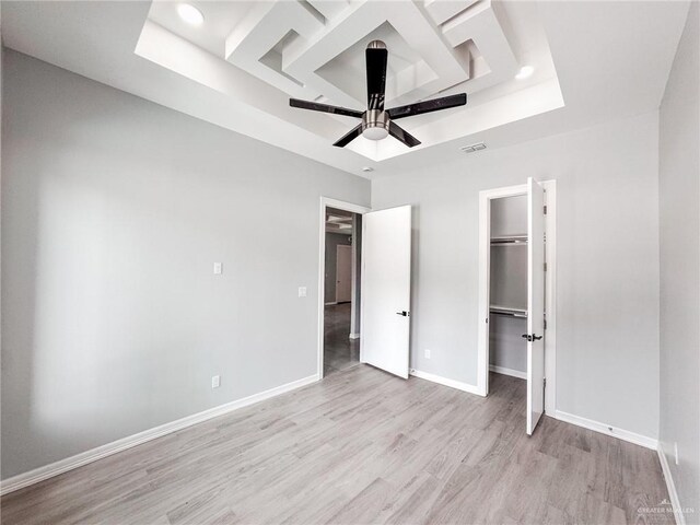 607 N 9th St, Alamo, TX 78516 - unfurnished bedroom featuring a raised ceiling, light wood-style flooring, a walk in closet, ceiling fan, and a closet