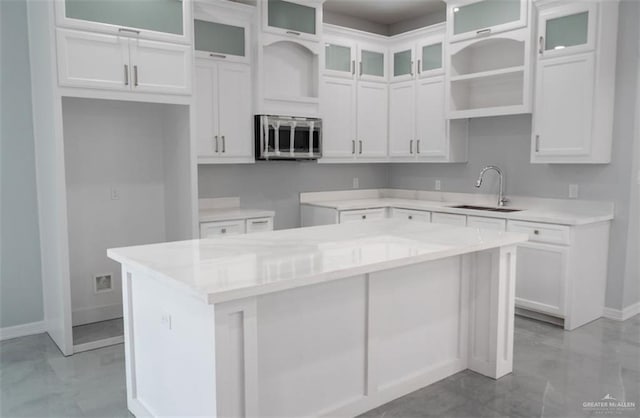 607 N 9th St, Alamo, TX 78516 - kitchen with stainless steel microwave, a center island, white cabinets, and open shelves