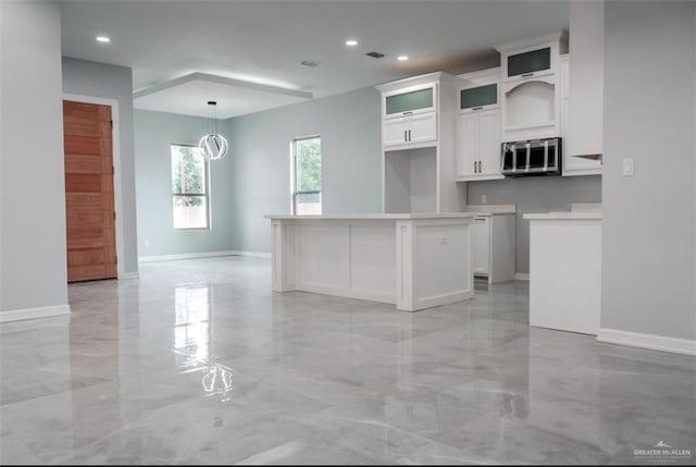 607 N 9th St, Alamo, TX 78516 - kitchen with stainless steel microwave, light marble finish flooring, white cabinetry, recessed lighting, and glass insert cabinets